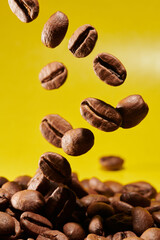Roasted coffee beans isolated close up on yellow background, clipping path