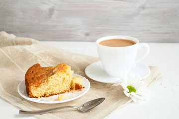 Piece of tasty rhubarb pie on white plate and cup of cocoa on wooden background wiht linen napkin. Delicious homemade baking. Concept seasonal summer pastry. Selective focus. Close-up.