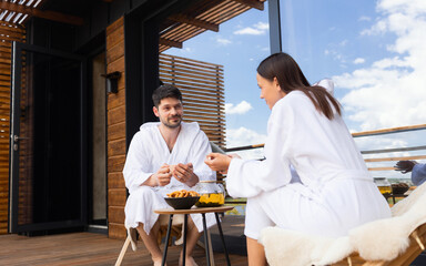 Cute couple drinking tea and talking on the hotel terrace after spa treatments