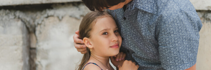man dad having time with kid daughter girl nine year hugs and straighten her hair. happy father playing with child. real life authentic day-to-day fatherhood moments. fatherly love care. banner