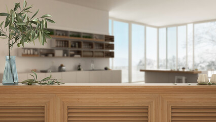 Wooden table top, cabinet, panel or shelf with shutters close up. Olive branch in vase and candles. Blurred background with modern minimalist white kitchen, interior design
