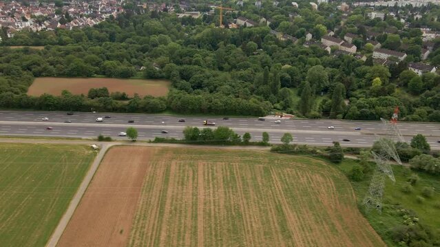 Afternoon traffic moving along the Highway a66 past Eschborn in Hesse, Germany. Aerial parallel following shot