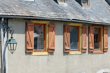 Fototapeta na wymiar Rustic wooden windows on the vintage french house in Arreau village, Pyrenees, France.