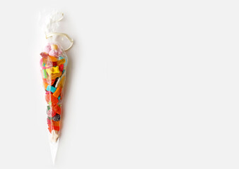 Jelly candies in transparent cone as present on white background with copy space, top view