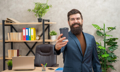 cheerful bearded business man drinking takeaway coffee in the office with copy space, to go