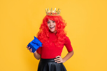 positive child in princess crown with present box on yellow background