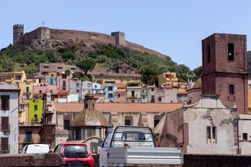 Cityscape of traditional village with colorful houses and cars in Bosa, Sardinia, Italy