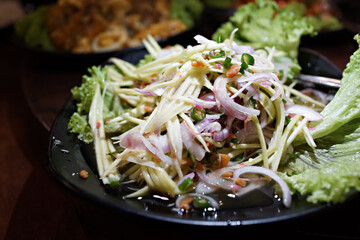 Close up image of a plate of green papaya Thai salads. Selective focus image.