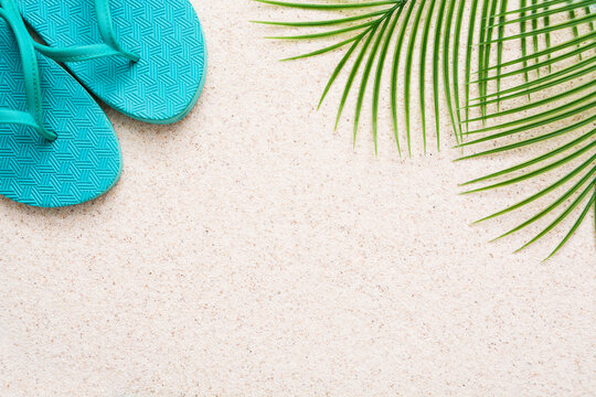 Summer minimalist mockup / template on a sand background with straw hat, flipflop, palm tree and sand. Tropical vacation concept.