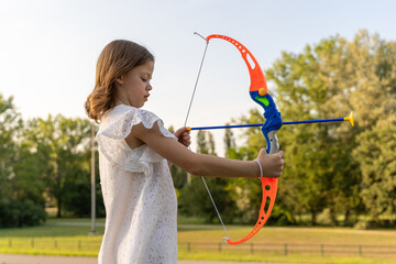cute little girl is playing with a toy bow and arrow