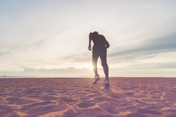 The man with runner on the desert at sunset. Running for exercise.