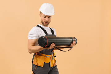 Positive construction engineer shows strength and muscles lifting drawings