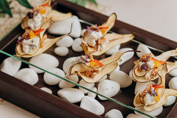 Dried fruit sliced Pear chips with cottage cheese and walnuts - healthy vegan dessert sugar free, served for furshet in restaurant