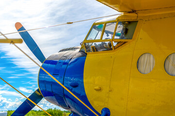 Close-up of an old classic airplane.Yellow biplane with a propeller against the sky. Retro plane at...