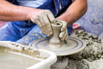 Pottery wheel and hands of the potter