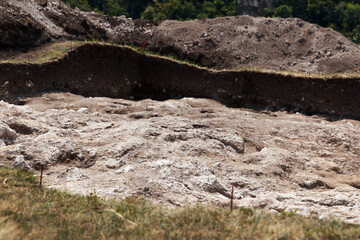 Rocky bottom of an archaeological pit dug on a hillside in search of historical artifacts