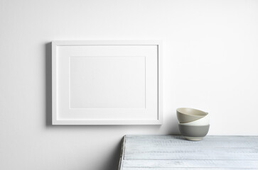 Blank artwork frame mockup on the wall in white room interior