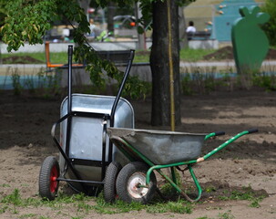 Two metal two-wheeled wheelbarrows in the garden