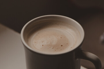 Fototapeta premium creamy latte in white mug under nightstand