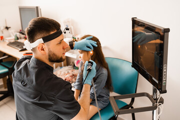 Ears endoscopy of child. Otoscopy procedure with otoscope. ENT doctor otolaryngologist treat ears...