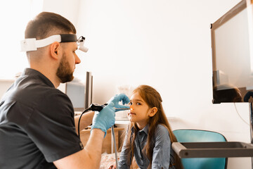 Nose endoscopy of child. Rhinoscopy procedure with rhinoscope. ENT doctor otolaryngologist with...