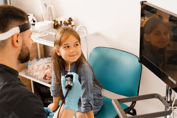 Nose endoscopy of child. Rhinoscopy procedure with rhinoscope. ENT doctor otolaryngologist with...