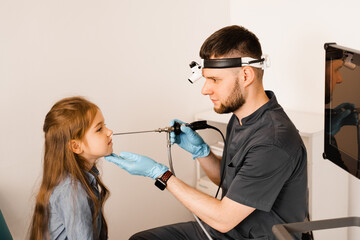 Nose endoscopy of child. Rhinoscopy procedure with rhinoscope. ENT doctor otolaryngologist with...