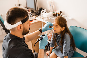 Nose endoscopy of child. Rhinoscopy procedure with rhinoscope. ENT doctor otolaryngologist with...