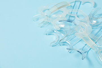 set of several Retractor Dental lip retractor Access to the oral cavity. Wide mouth opening for a dental procedure on a clean blue background