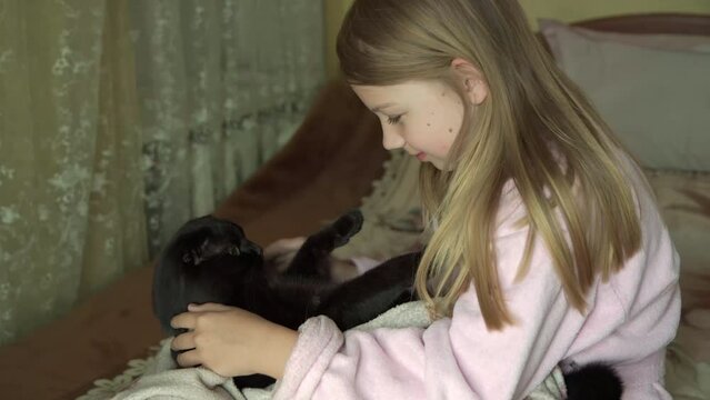 Young girl plays with her pet cat. 4k video.