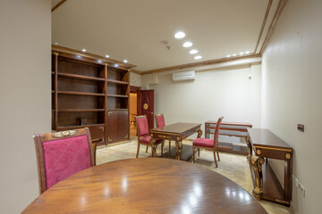 Office with wooden furniture with gold metal details and vintage upholstery