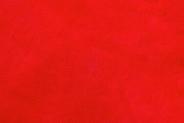 Red suede genuine leather background. Velvet red background close-up photo.