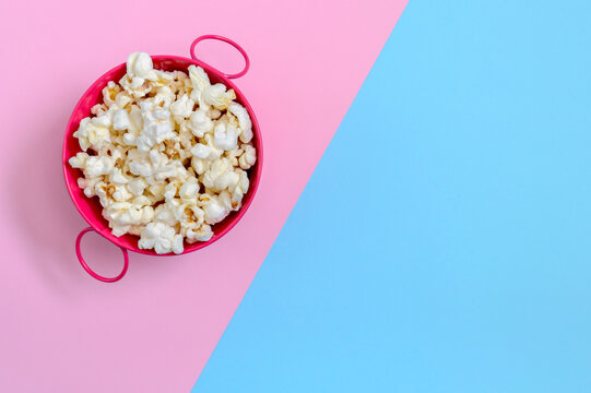 Bowl of popcorn on a bicolor background with copy space. Top view.