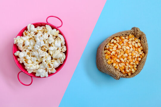 A bowl of popcorn and a bag of corn kernels on a bicolor background. Top view. Theme of production, food, agriculture