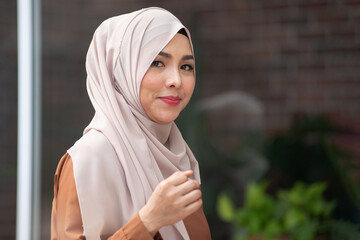 Asian muslim women wearing hijab with sweet smile on outdoor background