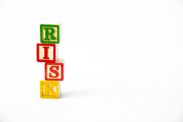 The word Risk spelled with a stack of colorful toy blocks