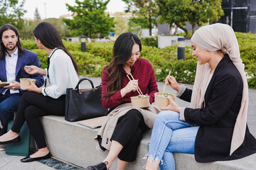 Multiracial business people eating fresh poke food during lunch break outside of office