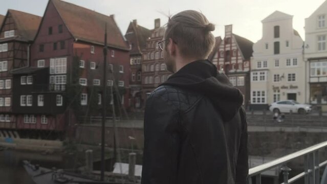 Parallax Shot of Young European Man on Bridge in L&uuml;neburg Oldtown