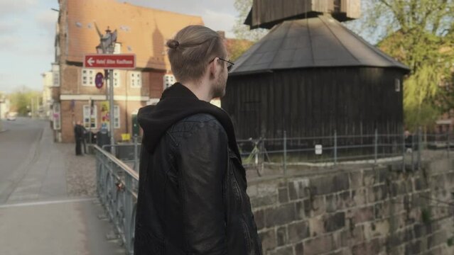 Man in Leather Jacket on Bridge in Historical Old Town in L&uuml;neburg