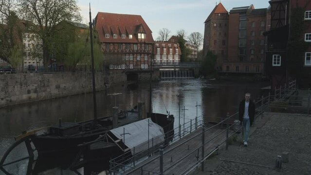 Historical Stintmarkt in L&uuml;neburg, Germany with Young Man Exploring