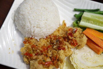 Ayam Geprek Indonesian Food crispy fried chicken with hot and spicy sambal Chili Sauce Served Steam Rice recipe.Currently ayam geprek found in Indonesia and neighbouring countries