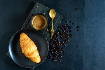 Breakfast food coffee and croissant in plate on wood table.