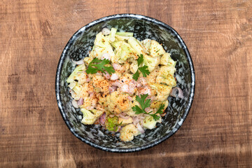 Healthy food cauliflower salad in bowl dish on wood background.