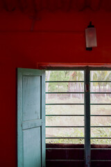 A vintage window on an orange painted wall. scene from a rural village in India.