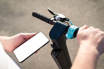 Hands of a person using a smartphone mobile application to pay for renting an electric scooter outdoors. Payment for transport services by electronic money. Eco-friendly transport © Andrii