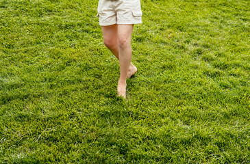 Woman feet barefoot closeup walking on green grass lawn Summer concept enjoying nature feeling