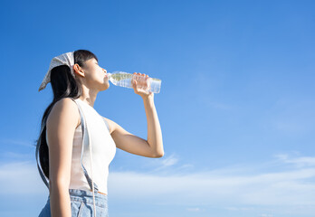 Portrait of woman drinking water outdoor.Asian Woman drink water for thirst,dream soft style.beautiful woman drinking water enough to meet the daily needs of freshness, smiling, strong in green fields