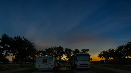 Motorhomes parked campsite under sunset sky with copy space