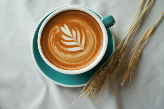 Top view of Hot coffee latte and heart shaped latte art in a white glass on a white background
