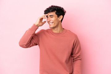 Young Argentinian man isolated on pink background laughing